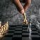 Hand of man playing chess for business planning and comparison of metaphor, selective focus