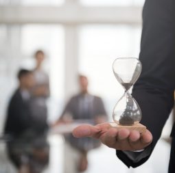 Businessman holding an hour glass, signifies the importance of being on time