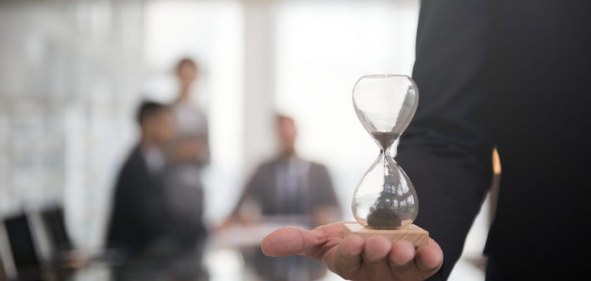 Businessman holding an hour glass, signifies the importance of being on time